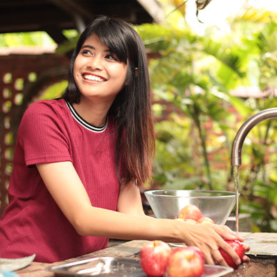 Woman Washing Apples In Outdoor Sink